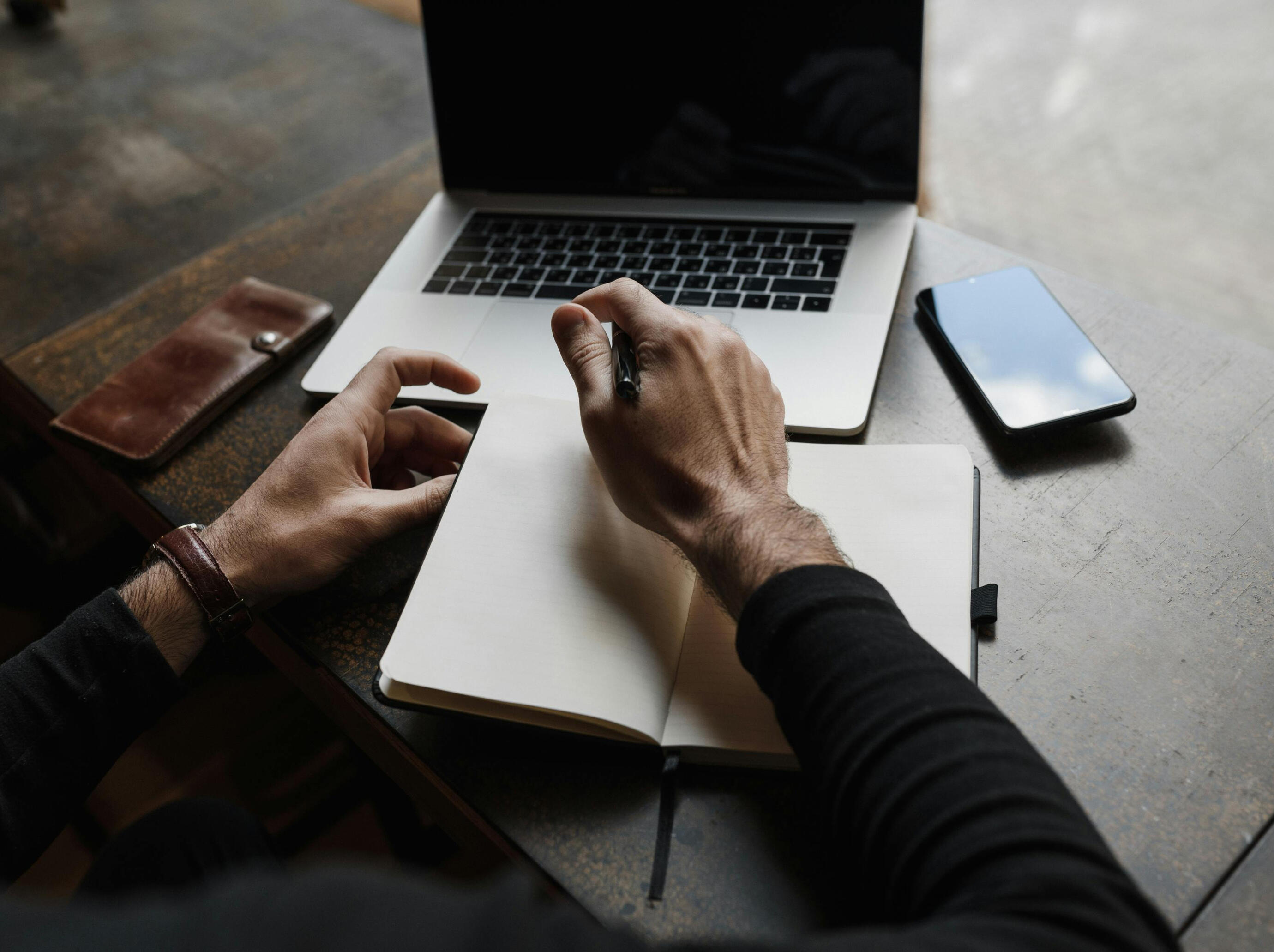 Hands working at laptop & journal